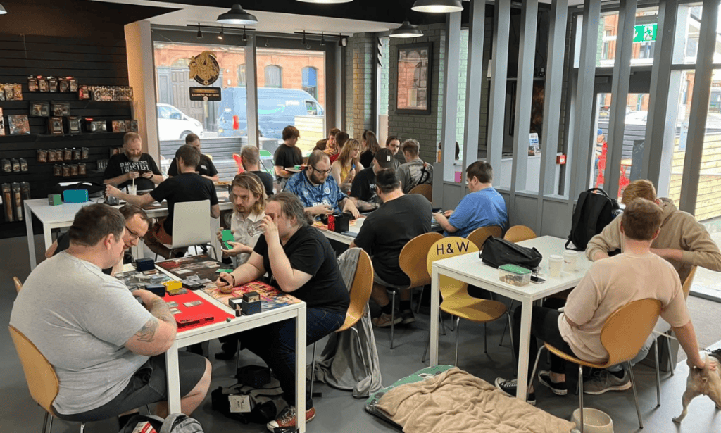 Groups of people sitting in Robin's Hobby Café playing board games